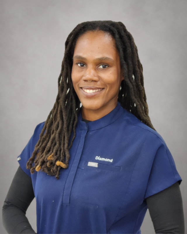 Portrait of Diamond, dental assistant wearing blue scrubs